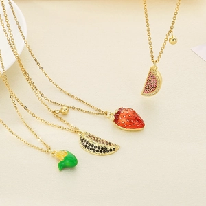 Close-up of golden necklaces featuring rhinestone strawberry, watermelon and corn pendants