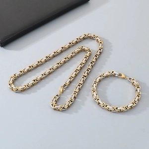 Close-up of gold and silver Byzantine chain necklace and bracelet set for men