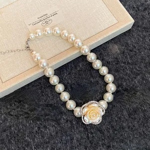 Macro shot of camellia pendant with sparkling diamonds and elegant white pearls
