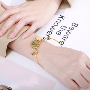 Gold adjustable stainless steel heart charm bracelet featuring a Love pendant for women