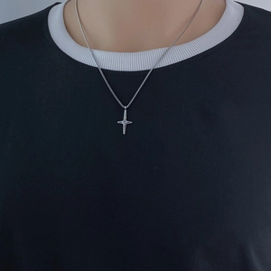 Close-up of a silver four-pointed star pendant necklace worn by a female model