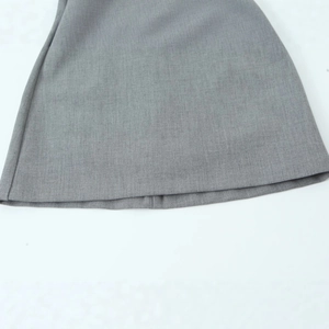 Close-up of the grey satin-texture mini dress hem featuring fine tailored stitching details