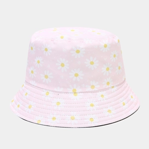 Close-up of pink bucket hat with white daisy floral pattern and fine cotton stitching