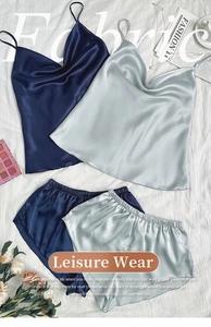 Ensemble caraco et short en satin bleu marine et gris argenté posé sur un tissu beige
