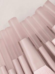 Dettaglio macro di setole morbide rosa e manici traslucidi opachi dei pennelli