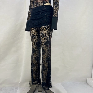 Detail of black lace stitching and sheer fabric texture on the slim fit long sleeve top