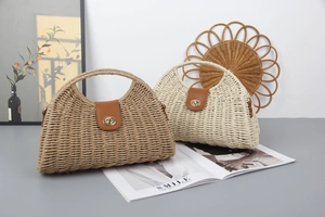 Detail of moon-shaped straw handbags in tan and beige with leather flaps and metal locks