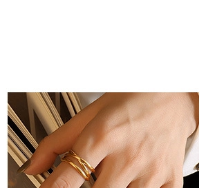 Detail of minimalist multi-layer gold layered ring showing crossed band design on hand