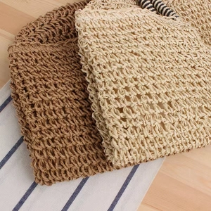 Detail of coarse fiber weave on brown and cream straw bags for summer beach trips