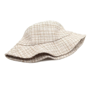Close-up of the thick tweed weave texture and beige checkered pattern on the bucket hat