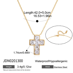 Macro detail of gold stainless steel cross necklace with cubic zirconia and lobster clasp