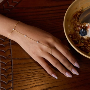 Elegant gold slave bracelet with sparkling cubic zirconia on a model's hand