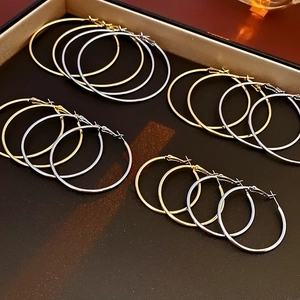 Polished silver and gold round hoop earrings in various sizes inside a jewelry box