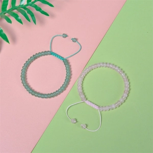 Close-up of adjustable bead bracelets with green and pink translucent abacus stones