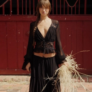 Detailed view of the sheer black lace V-neck top with ruffled sleeves and tiered skirt