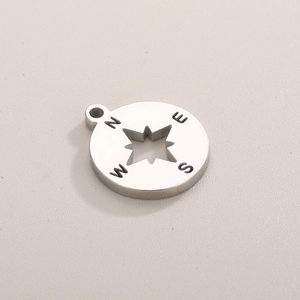 Macro view of silver star compass pendant featuring N E S W direction engravings