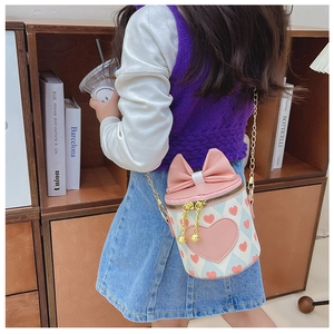Detail showing a girl wearing a pink and blue bucket bag with heart prints and bow decoration