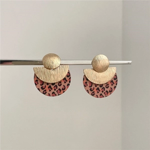 Detail of geometric leopard print earrings with gold brushed metal in a retro style