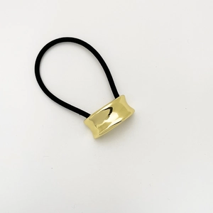 Close-up of elastic hair tie featuring a polished gold-finish minimalist alloy u-shape detail