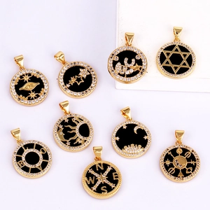 Micro-paved copper charms with gold plating and black enamel symbols on white surface