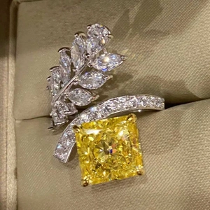 Macro shot of square yellow diamond ring with marquise leaf accents on velvet