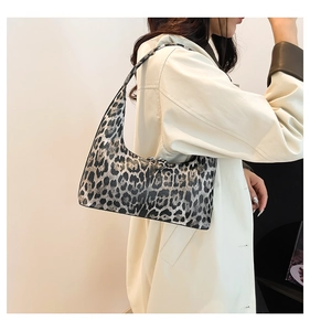 Chic leopard print hobo bag worn by a model in a stylish trench coat outfit