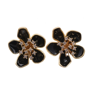 Elegant gold flower earrings with black petals and sparkling central diamonds on white base
