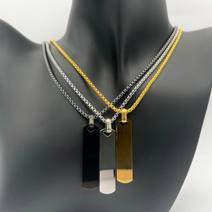 Detailed view of rectangular bar necklaces in gold, silver and black on a display