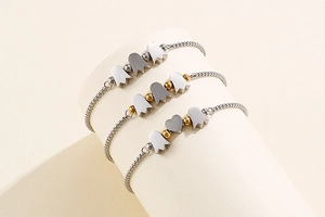 Detail of silver beaded bracelets with heart and tulip pendants on a display stand