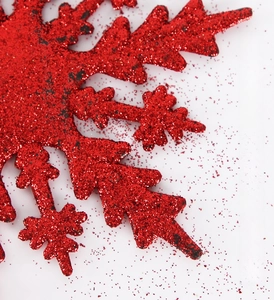 Macro di fiocco di neve rosso glitterato che mostra la struttura stellare esagonale