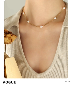 Detail of elegant gold flat chain choker with five natural oval freshwater pearls