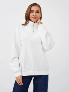 Detail of white half-zip sweatshirt showing stand-up collar and ribbed cuffs