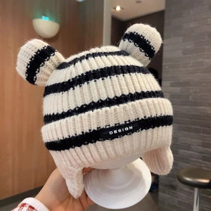 Detail of baby knit hat with black and white stripes, bear ears and ear flaps
