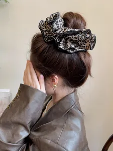 Dettaglio di un grande elastico scrunchie leopardato su una coda di cavallo bassa