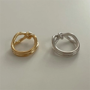 Polished silver and gold double-layered knot rings with a smooth metallic finish
