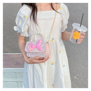 Close-up of pink sequin bag with pearl handle and mermaid tail decoration