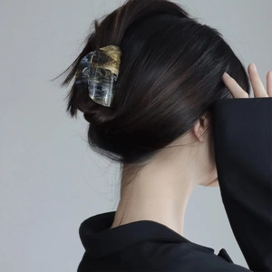 Detail of amber marble hair claw clip worn on hair with minimalist aesthetic