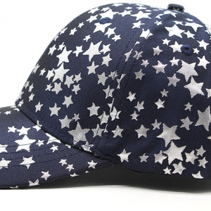 Detailed close-up of navy blue baseball cap featuring silver star prints and twill texture
