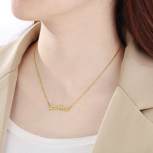 Close-up of a gold necklace featuring a grandma heart pendant worn by a model