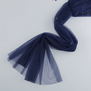 Détail macro du tissu en maille bleu foncé avec ornements en paillettes sur une robe