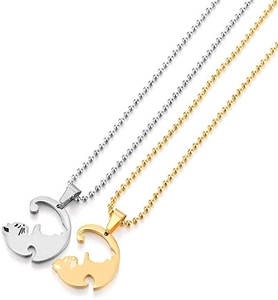 Close-up of interlocking silver and gold cat pendants forming a Yin Yang circle