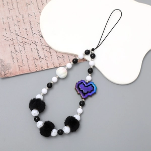 Detail of beaded phone strap featuring a black plush ball and pixel heart pendant