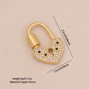 Macro detail of a gold-plated brass heart lock pendant with white and black zircon stones
