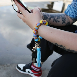 Close-up of colorful silicone bead wristlet keychain with blue tassel and gold clasp