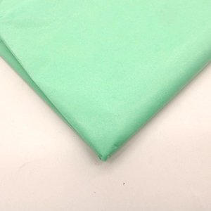 Macro shot of layered light green tissue paper with fine texture for gift wrapping