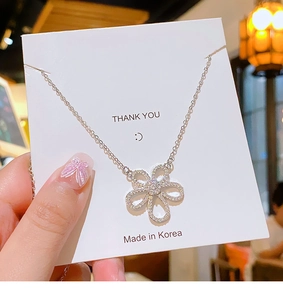 Macro detail of silver flower pendant necklace featuring micro-set sparkling zircons
