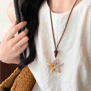 Close-up of ocean-style starfish pendant on brown cord with a rustic wood bead detail