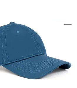 Detail showing deep blue cotton baseball cap with curved brim and reinforced stitching
