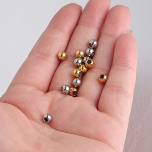 5mm stainless steel gold and silver beads in palm showing scale for jewelry making