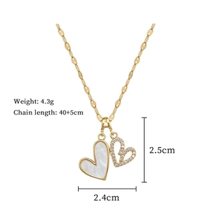 Détail du pendentif double cœur avec nacre et cristaux sur une chaîne dorée